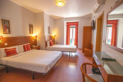 里斯本阿露比雅格兰德盘沙住宅酒店的酒店客房配有两张床和一张书桌