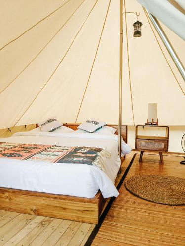 塔巴南PukuPods - Tent & Cabin的帐篷内一间卧室,配有一张床