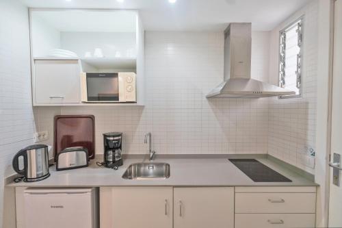美洲海滩Coral California - Adults Only的白色的厨房配有水槽和微波炉