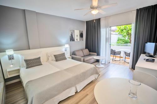 美洲海滩Coral California - Adults Only的酒店客房设有一张大床和一间客厅。