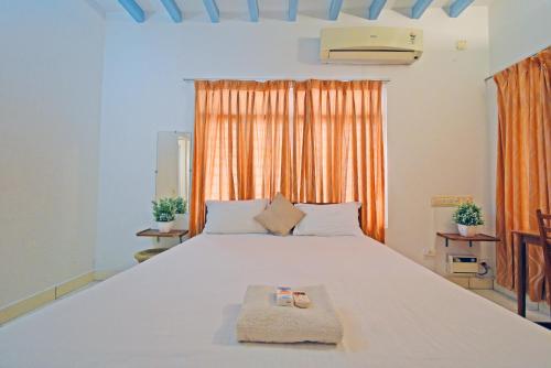 蓬蒂切里Villa Waves的卧室在窗户前配有一张白色大床