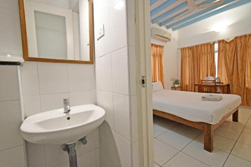 蓬蒂切里Villa Waves的一间带水槽的浴室和一张位于客房内的床