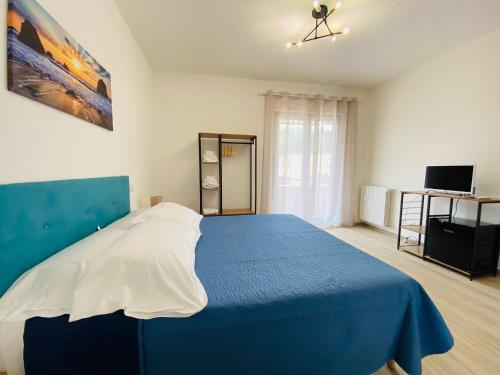 波尔图·埃尔科莱Guest House Tramontana 19的一间卧室配有蓝色的床和蓝色的毯子