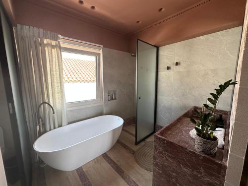埃尔莫波利斯Igisó的一间带大型白色浴缸和窗户的浴室