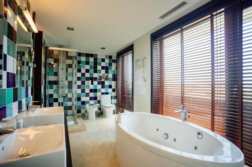 波尔图轴波尔图商务及水疗酒店的带浴缸、两个盥洗盆和卫生间的浴室