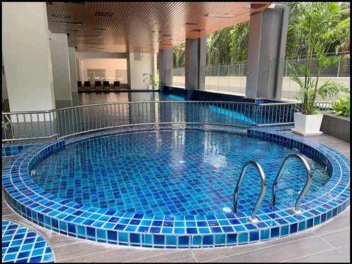 斯里曼绒Manjung CY Homey Stays The Venus Residence的大楼内一个蓝色瓷砖的大型游泳池