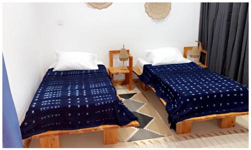 圣菲利佩Pipi's Guest House的两张睡床彼此相邻,位于一个房间里