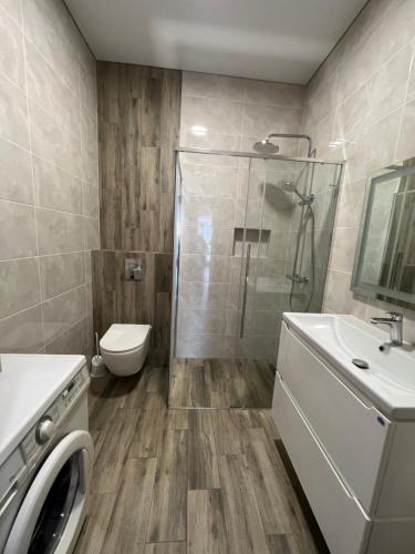 罗夫诺VIP апартаменти біля озера的带淋浴、卫生间和盥洗盆的浴室