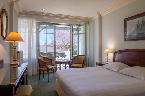 圣梅卢瓦代翁德Domaine du Limonay, The Originals Collection的酒店客房带一张床、一张桌子和椅子