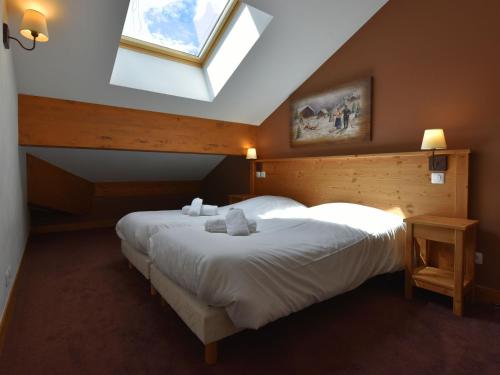 圣福瓦-塔朗泰斯Apartment close to ski lift in Sainte Foy的一间卧室设有两张床和天窗