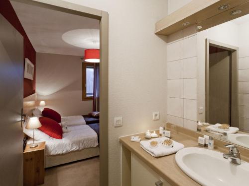圣福瓦-塔朗泰斯Apartment close to ski lift in Sainte Foy的一间带水槽的浴室和一间带一张床的卧室