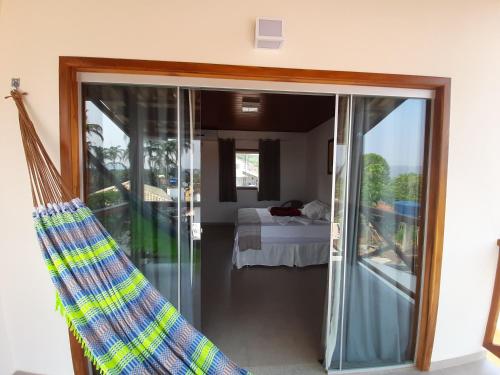 戈亚斯州上帕莱索POUSADA ACONCHEGO CHAPADA的一间设有玻璃门的客房,可通往一间卧室