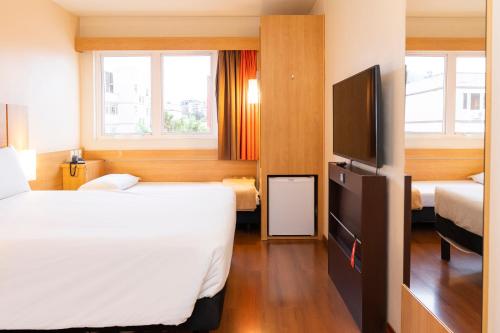 阿雷格里港宜必思博尔特阿尔格雷温托酒店的酒店客房设有两张床和一台平面电视。