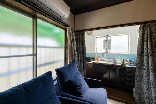 尾道市Bed&Cafe Onzo オンゾー的带沙发的客厅和带窗户的厨房