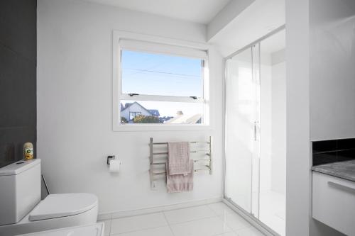 基督城Spacious Quality Apartment, Convenient Location的白色的浴室设有卫生间和窗户。