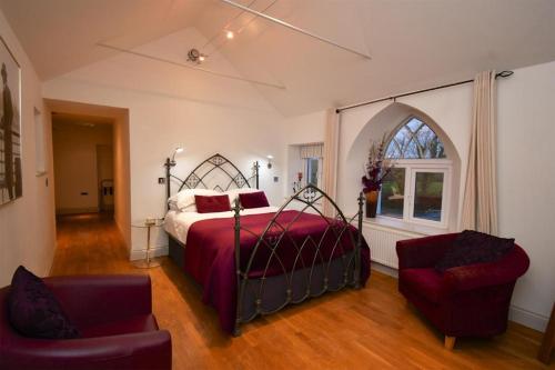 马诺比尔Tudor Lodge Bed & Breakfast的卧室配有床、椅子和窗户。