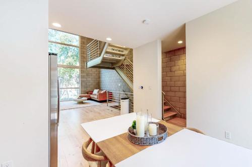洛杉矶Modern Loft-Style Townhouse in Los Angeles的一间带桌子和楼梯的客厅