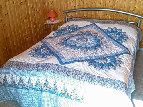 巴特Bungalow am Waldrand的床上有蓝色和白色的被子