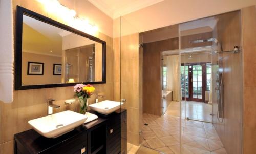 Lidgetton里特伍德旅馆的浴室设有2个盥洗盆、淋浴和镜子。