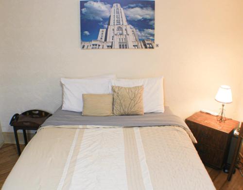 匹兹堡Comfortable Apartment - Pittsburgh's Little Italy的一张带两个枕头的床和一张墙上的照片