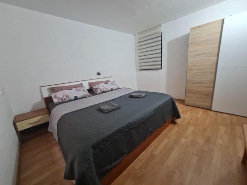 维尔Apartmani Jadro的一间卧室设有一张大床,铺有木地板