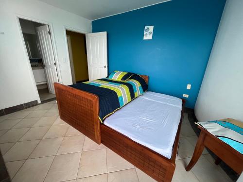赛姆Exclusivo departamento frente al mar en Same, Casa Blanca的一间小卧室,配有一张床和蓝色的墙壁