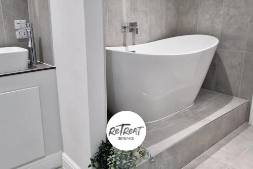 利兹ReTreat Breaks - 3 Bedroom Penthouse - Holbeck Leeds的带浴缸和盥洗盆的浴室
