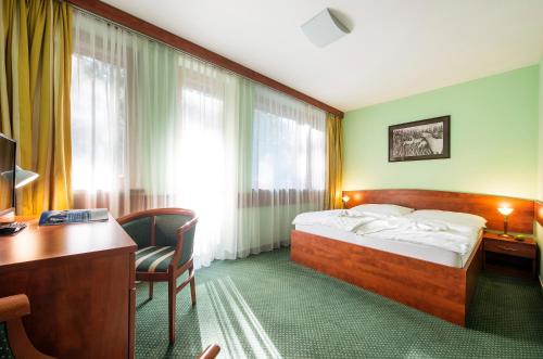 迪马诺卡多林纳婆洛芙尼克酒店的酒店客房配有一张床、一张书桌和一台电脑