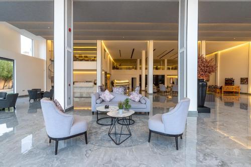 利雅德فندق هوليداي الخليج النجاح的大堂配有沙发、椅子和桌子