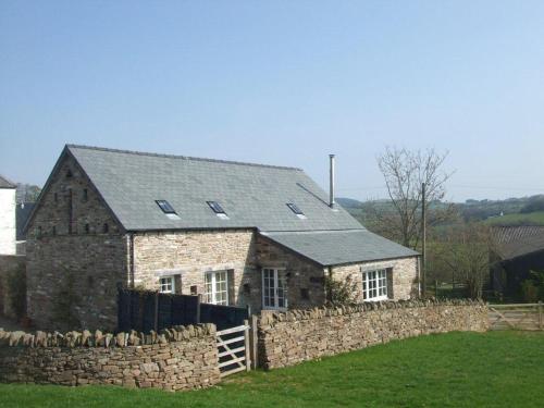 布雷肯Alltybrain Farm Cottages and Farmhouse B&B的石头房子前面有石墙