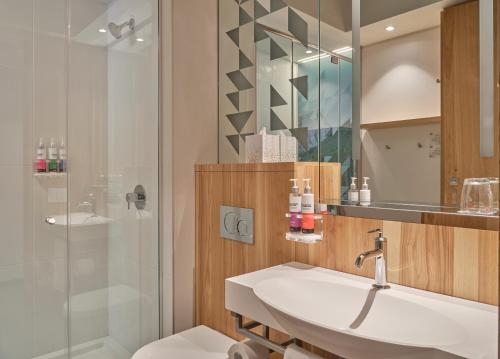 卡尔加里Alt Hotel Calgary University District的一间带水槽和淋浴的浴室