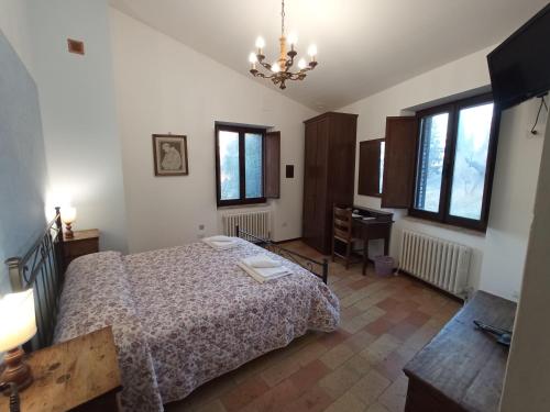 阿西西All'Ombra di San Damiano的卧室配有一张床、一张书桌和窗户。
