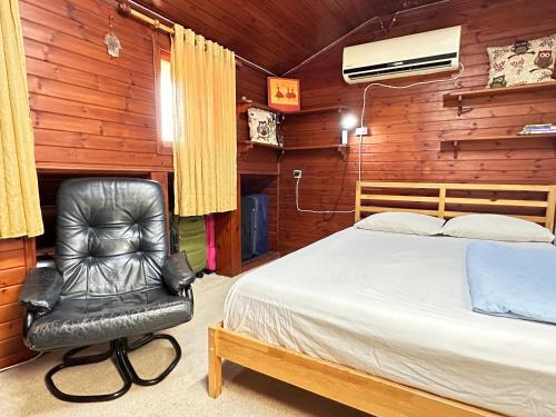 荷兹利亚Cosy room near IDC & Center- Herzliya Homestay的一间卧室配有一张床和一张黑色皮椅