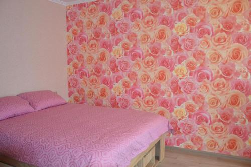 里加Julia Apartment Riga Imanta的一间卧室设有一张床和一堵玫瑰墙