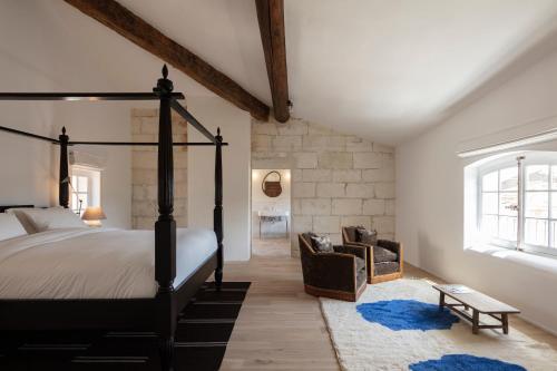 瓦拉布雷格Maison Salix的一间卧室配有一张四柱床和一把椅子
