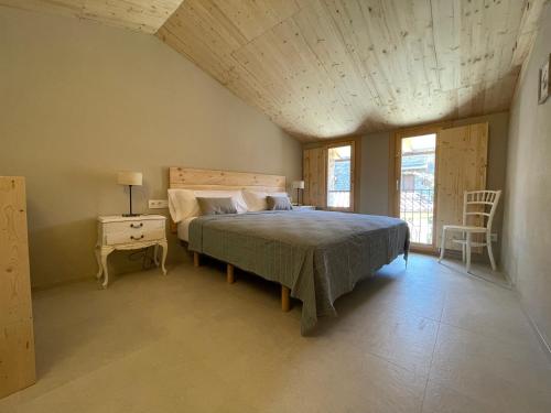 贝尔维尔德赛当亚CAL GALL rural Cerdanya的一间卧室配有一张床和一张桌子及椅子