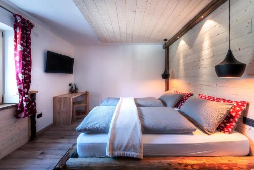 索拉加Ciasa Marizana的一间卧室配有蓝色和红色枕头的床