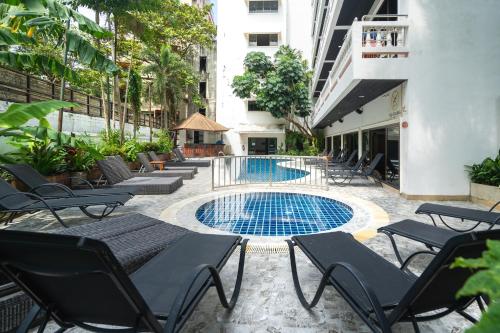 芭东海滩Patong Central Residence and Apartment的一个带椅子的庭院和一个游泳池