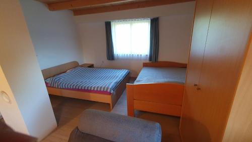 PolzelaHiška ob gozdu的小房间设有两张床和窗户