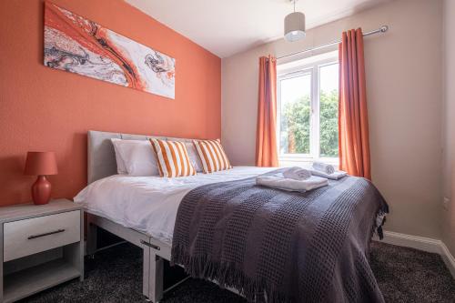 BirstallStunning Home Ideal for Business - Free Parking的一间卧室拥有橙色的墙壁、一张床和窗户