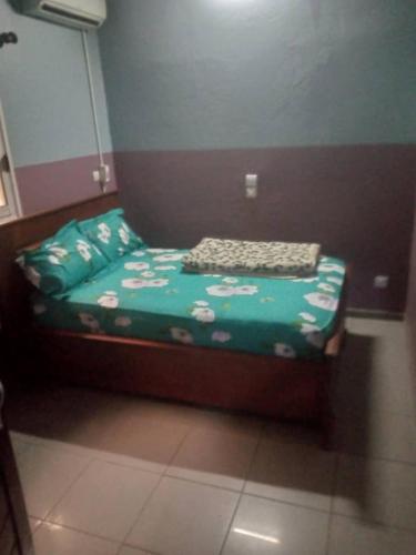 杜阿拉Grace and favour guest house的一张小床,位于带绿叶的房间里
