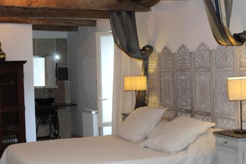 Mirandol-BourgnounacLa maison Cayré的一间卧室配有一张带白色床单和两盏灯的床。