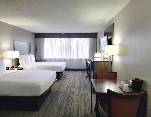 罗瑞尔罗瑞尔品质套房酒店的酒店客房设有两张床和一张桌子。