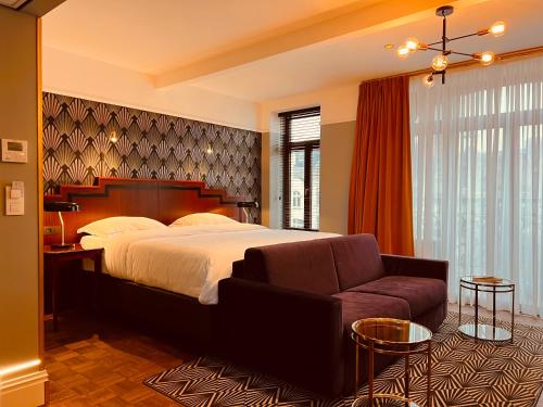 布兰肯贝赫Gatsby Hotel - Adults Only - Small Luxury Hotel - by F-Hotels的一间卧室配有一张大床和一张沙发