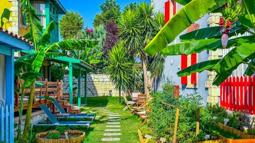 阿拉恰特Banana Alaçatı Wellness Hotel - Adults Only的一座花园,在一座建筑前,花园内种有椅子和棕榈树