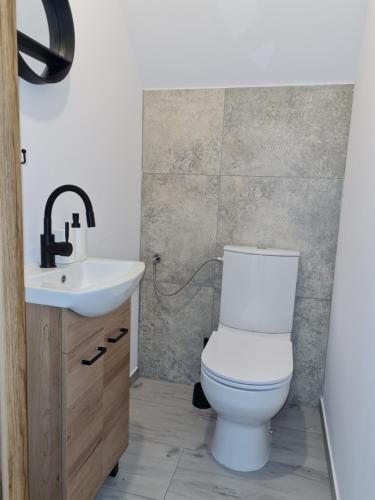 新塔尔格Bocheniówka的浴室配有白色卫生间和盥洗盆。