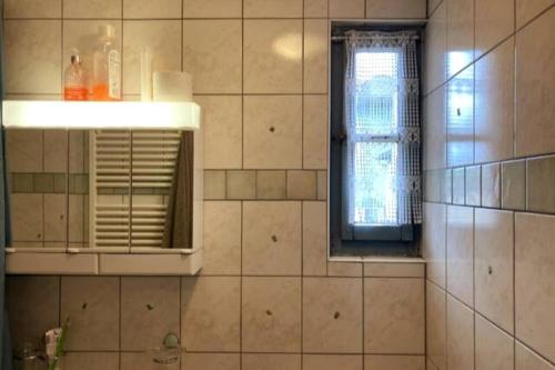 Les VerrièresCharmante maison individuelle的浴室设有窗户和瓷砖墙。