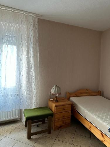 森海姆Ferienwohnung Vogtei7的卧室配有床、椅子和窗户。