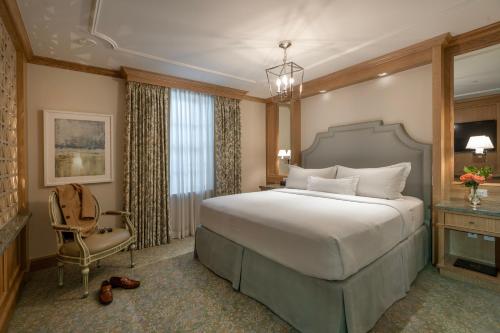 新奥尔良蒙特莱昂酒店的一间卧室配有一张大床和一把椅子