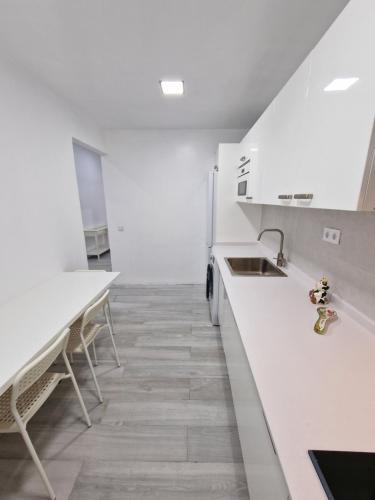 大加那利岛拉斯帕尔马斯GUANARTEME 33的厨房配有白色的台面、水槽和桌子